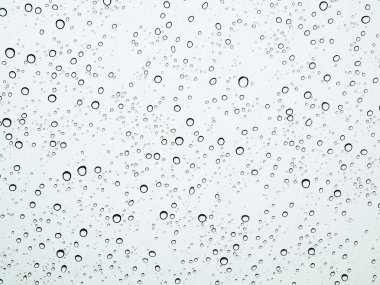 Yağmur mevsiminde cam arabanın üzerindeki yağmur damlaları.