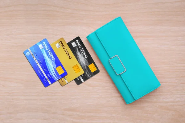 木のテーブルの背景に財布やクレジットカードのトップビュー — ストック写真
