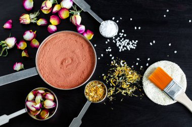 Küçük top Fas kırmızı kil, Kuru gül tomurcukları, kadife çiçeği çiçek ve ölü deniz tuzu. DIY maskeler doğal cilt ve saç bakımı için hazırlanması için malzemeler. Ev yapımı kozmetik kavramı. Kopya alanı, üstten görünüm.