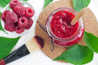 Ev yapımı ahududu yüz ve vücut maskesi/bir cam kavanoza fırçalayın. DIY kozmetik ve spa. Üstten görünüm, kopya alanı. 