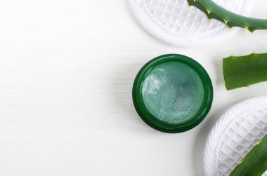 Aloe vera şifa merhem (merhem, merhem, yüz kremi veya maske) ile küçük yeşil kavanoz. Doğal güzellik treaments ve spa. Beyaz arka plan. Üstten görünüm, kopya alanı. 