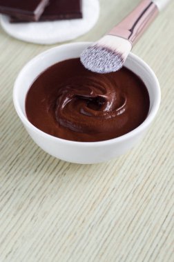 Küçük beyaz kase DIY kakao (bitter çikolata) ile yüz maskesi. Ev yapımı güzellik bakımı. Kopya alanı. 