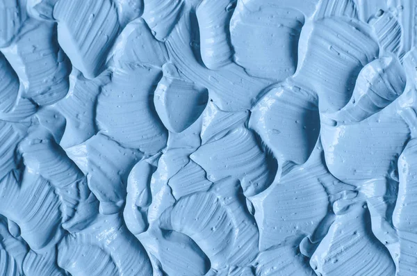 Light blue cosmetic clay (facial mask, cream, body scrub) texture close up. Abstract background with brush strokes.