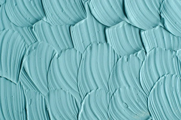 Light blue cosmetic clay (facial mask, cream, body scrub) texture close up. Abstract background with brush strokes.