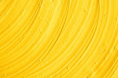 Sarı kozmetik yüz maskesi (krem, vücut scrub) doku yakın kadar seçici odak. Fırça darbeleri ile arka plan.   