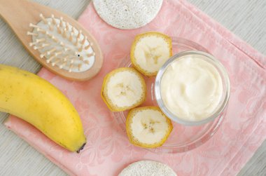 Ev yapımı muz yüz ve saç maskesi (küçük cam kavanoz ve kozmetik fırça krem). DIY güzellik bakımı ve spa. Üstten Görünüm, kopya alanı.