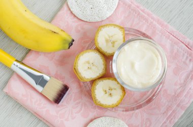 Küçük cam kavanoz ve kozmetik fırça ev yapımı muz yüz maskesi (nemlendirici). DIY Güzellik bakımları ve spa. Üstteki görünüm, kopya alanı. 