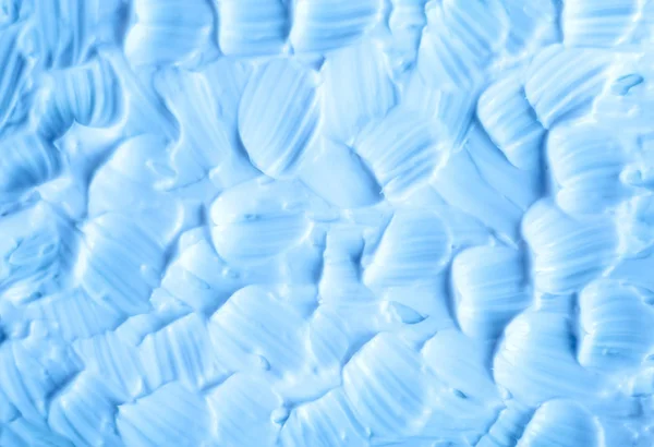 Açık mavi yüz kremi (nemlendirici, maske, vücut sarma) doku yakın yukarı. Fırça vuruşları. Seçmeli odak. Soyut arka plan  