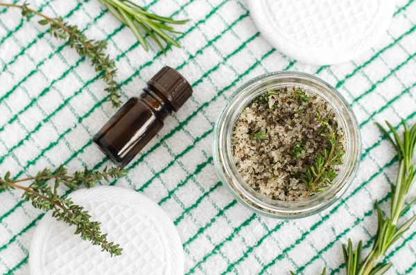 Homemade herbal scrub (foot soak or bath salt) with rosemary, thyme, sea salt, olive oil and essential oils. Natural skin and hair care. DIY beauty treatments and spa recipe. Top view, copy space