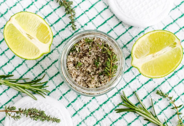 Homemade herbal scrub (foot soak or bath salt) with rosemary, thyme, lime juice, sea salt and olive oil. DIY beauty treatments and spa recipe. Top view, copy space