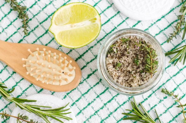 Homemade herbal scrub (foot soak or bath salt) with rosemary, thyme, lime juice, sea salt and olive oil. DIY beauty treatments and spa recipe. Top view, copy space