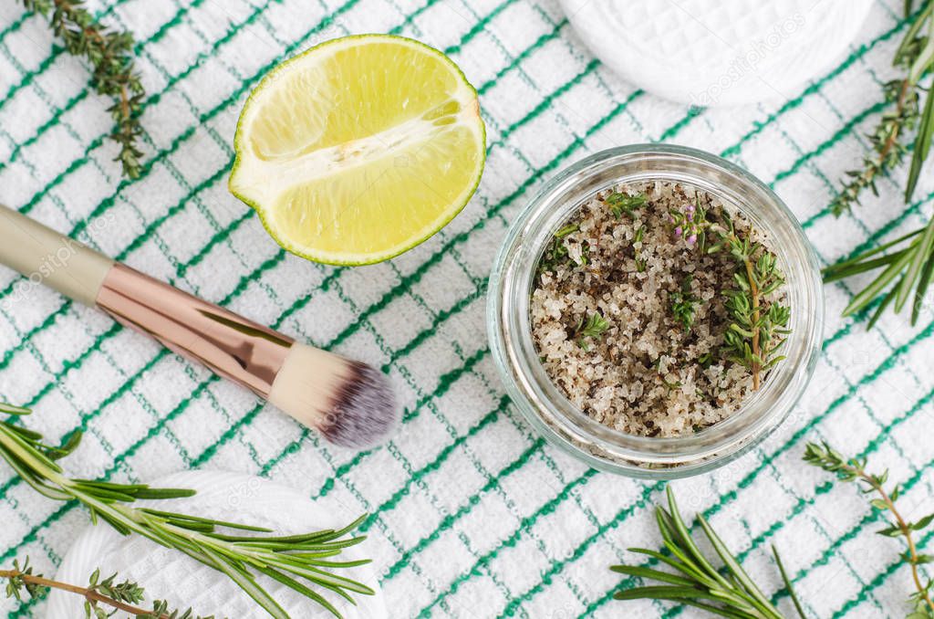 Homemade herbal scrub (foot soak or bath salt) with rosemary, thyme, lime juice, sea salt and olive oil. DIY beauty treatments and spa recipe. Top view, copy space 