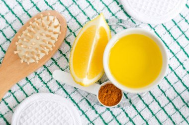 Zeytin yağı, limon, zerdeçal tozu ve ahşap saç fırçası. DIY yüz ve saç maskeleri ve nemlendiricileri hazırlamak için malzemeler. Ev yapımı güzellik bakımları tarifi. Üst görünüm. 