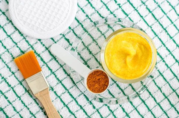 Turmeric powder and greek yogurt (sour cream or kefir) facial mask. Ingredients for preparing diy face and hair masks and moisturizers. Homemade beauty treatments recipe. Top view. — Stock Photo, Image