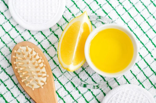 Küçük kasede zeytinyağı, limon ve ahşap saç fırçası. Diy yüz ve saç maskeleri ve nemlendiriciler Malzemeler. Ev yapımı güzellik bakımları tarifi. Üst görünüm, kopyalama alanı.