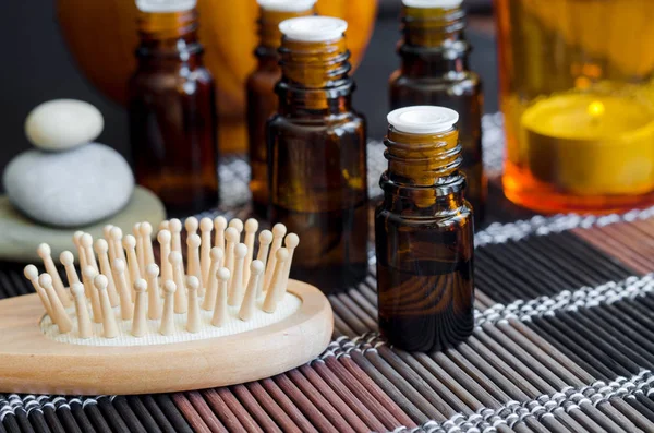 Botol kecil dengan minyak esensial dan sikat rambut kayu. Aromaterapi, spa dan konsep pengobatan herbal. Salin ruang . — Stok Foto