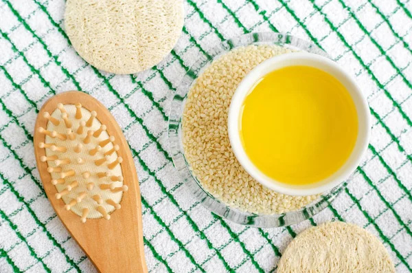 Huile de sésame et graines dans le petit bol. Brosse à cheveux en bois. Ingrédients de masques et d'hydratants pour le visage et les cheveux. Recette de soins de beauté maison. Vue du dessus, espace de copie . — Photo