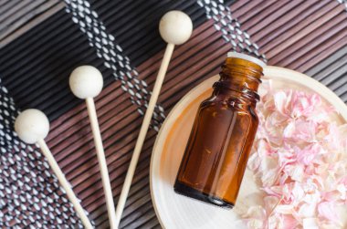 Kuru pembe sardunya çiçekleri ve ahşap sazlık ile küçük bir tabak üzerinde uçucu yağ ile küçük şişe. Kurutulmuş çiçek yaprakları ile Arka plan. Aromaterapi, spa ve bitkisel ilaç kavramı. Kopya alanı, üst görünüm. 
