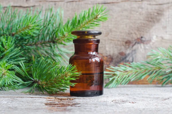 Apoteksflaska med eterisk tallolja (extrakt, tinktur, infusion). Gammal träbakgrund. Aromaterapi, spa och örtmedicin koncept. Kopiera utrymme. — Stockfoto