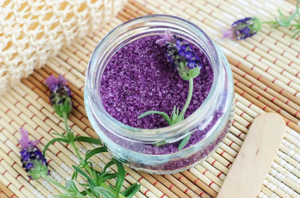 Homemade purple exfoliating scrub (foot soak or bath salt) with essential lavender oil. Topped lavender flower in the jar. Natural skin and hair care. DIY beauty treatments and spa recipe. Copy space.