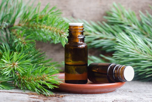 Dua botol kecil dengan minyak pinus esensial (ekstrak, jahitan, infus). Latar belakang kayu tua. Aromaterapi, spa dan konsep pengobatan herbal. Salin ruang . — Stok Foto