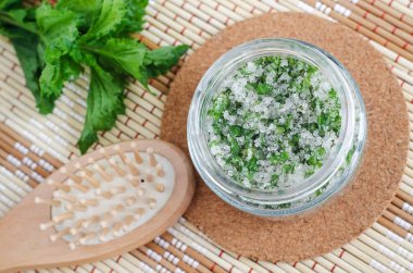 Şeker, doğranmış nane yaprakları, zeytinyağı ve uçucu nane yağı ile ev yapımı nane peeling scrub (kafa derisi soyma, banyo tuzu) Doğal cilt ve saç bakımı. Diy güzellik tedavileri, spa tarifi.  