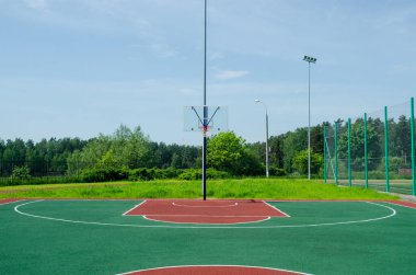 Güneşli yaz gününde parkta boş bir basketbol sahası.. 