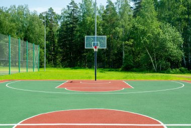 Güneşli yaz gününde parkta boş bir basketbol sahası.. 