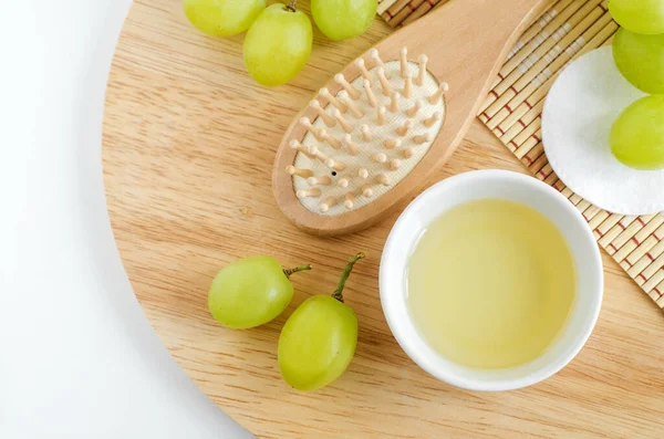 Mangkuk Kecil Dengan Minyak Biji Anggur Dan Sikat Rambut Kayu — Stok Foto