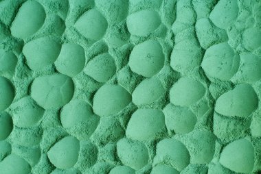 Yeşil kozmetik kil tozu (yosun maskesi, spiulina vücut ambalajı) dokusu yakın, seçici odaklanma. Fırça darbeleriyle soyut arkaplan. 