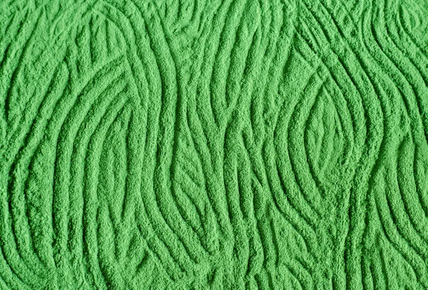 Green cosmetic clay powder (green tea matcha body wrap, spirulina face mask) texture close up, selective focus. Abstract background with brush strokes.