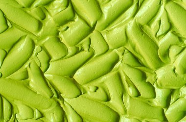 Yeşil kozmetik kil (salatalık yüz maskesi, avokado yüz kremi, yeşil çay eşleşmesi vücut ambalajı) yakından seçici odaklanma. Fırça darbeleriyle soyut arkaplan. 