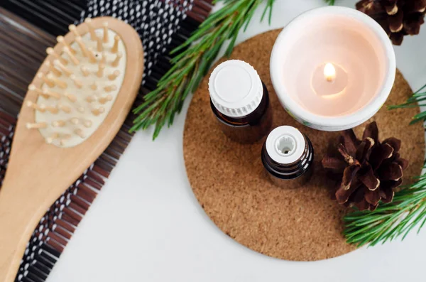 Kleine Glazen Flesjes Met Essentiële Pijnboomolie Brandende Kaars Houten Haarborstel — Stockfoto