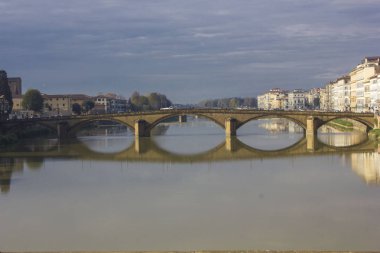 Florence, İtalya - 25 Kasım 2015: Ön görünümü ile onun yansıması su Arno Nehri, Floransa'da Carraia Köprüsü'nün