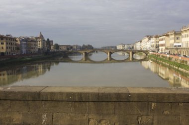 Florence, İtalya - 25 Kasım 2015: Ön görünümü ile onun yansıması su Arno Nehri, Floransa'da Carraia Köprüsü'nün