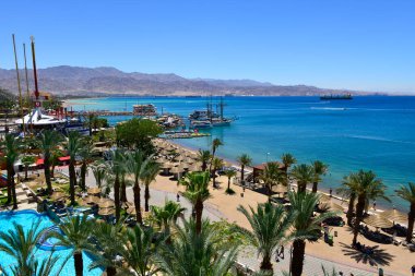 Yazın deniz tatil köyü, Palmiyeler ve otel mimarisi ile kıyı şeridi 