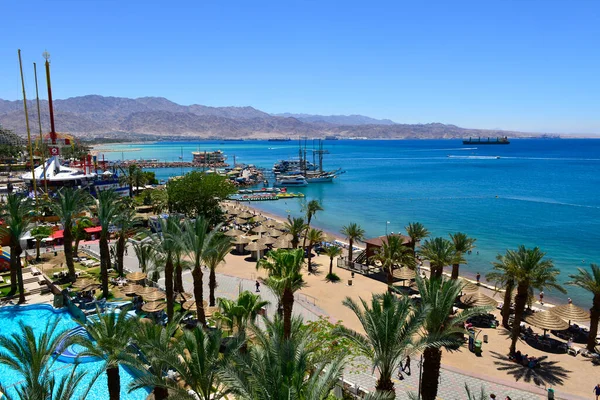 Yazın deniz tatil köyü, Palmiyeler ve otel mimarisi ile kıyı şeridi 