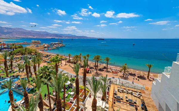 Yazın deniz tatil köyü, Palmiyeler ve otel mimarisi ile kıyı şeridi 