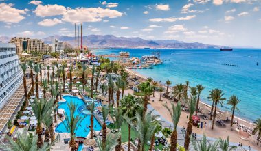 Yazın deniz tatil köyü, Palmiyeler ve otel mimarisi ile kıyı şeridi 