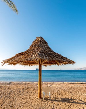 Deniz, kumlu sahil ve şemsiyeli yaz tatili 