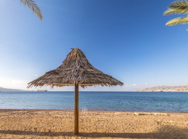 Plaj şemsiyeleri ve sandalyeler kumlu tropikal denizde