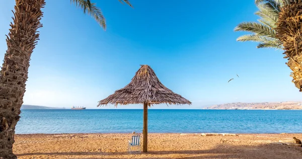 Akdeniz 'in kumlu sahillerinde plaj şemsiyeleri ve sandalyeler