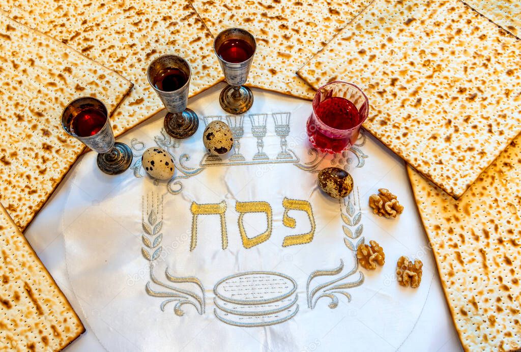 Festive collage with traditional food symbolizing Hebrew Passover holiday. Text translation of three Hebrew letter on white napkin means the ritual Jewish ceremony of blessing to exodus from servitude
