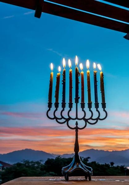 Dağların üstündeki bulanık bulutlu sabaha karşı yanan mumlarla menorah