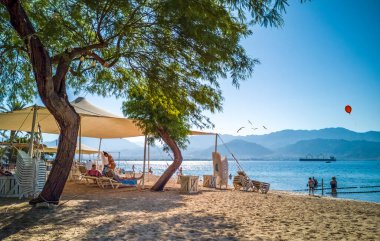 Eilat, İsrail 07 Ağustos 2020: Eilat, İsrail 'deki Kızıldeniz' de kumlu, rahatlatıcı plajda güneşli bir gün