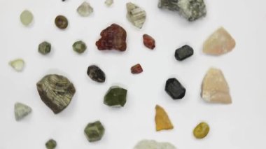 Çeşitli mineraller, kristaller, beyaz arka planda dönen yarı değerli taşlar.