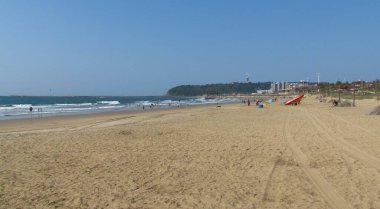 Arka planda kayalık olan Durban sahili..