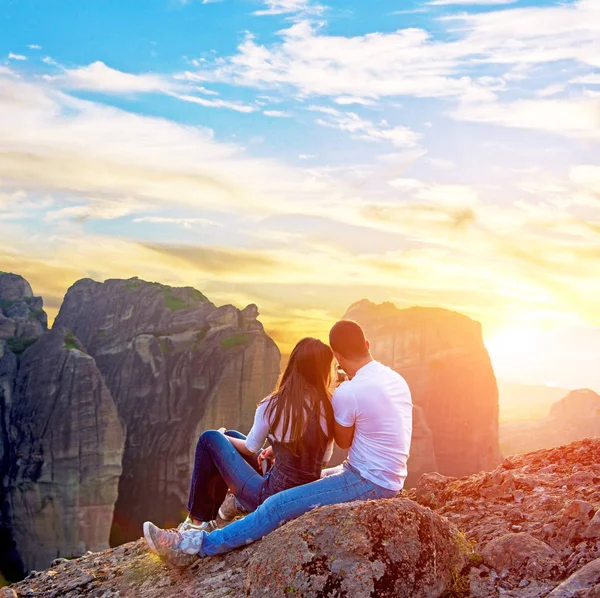 Seven çift bir fotoğrafı dağlarda bir cep telefonunda günbatımında kılıyor