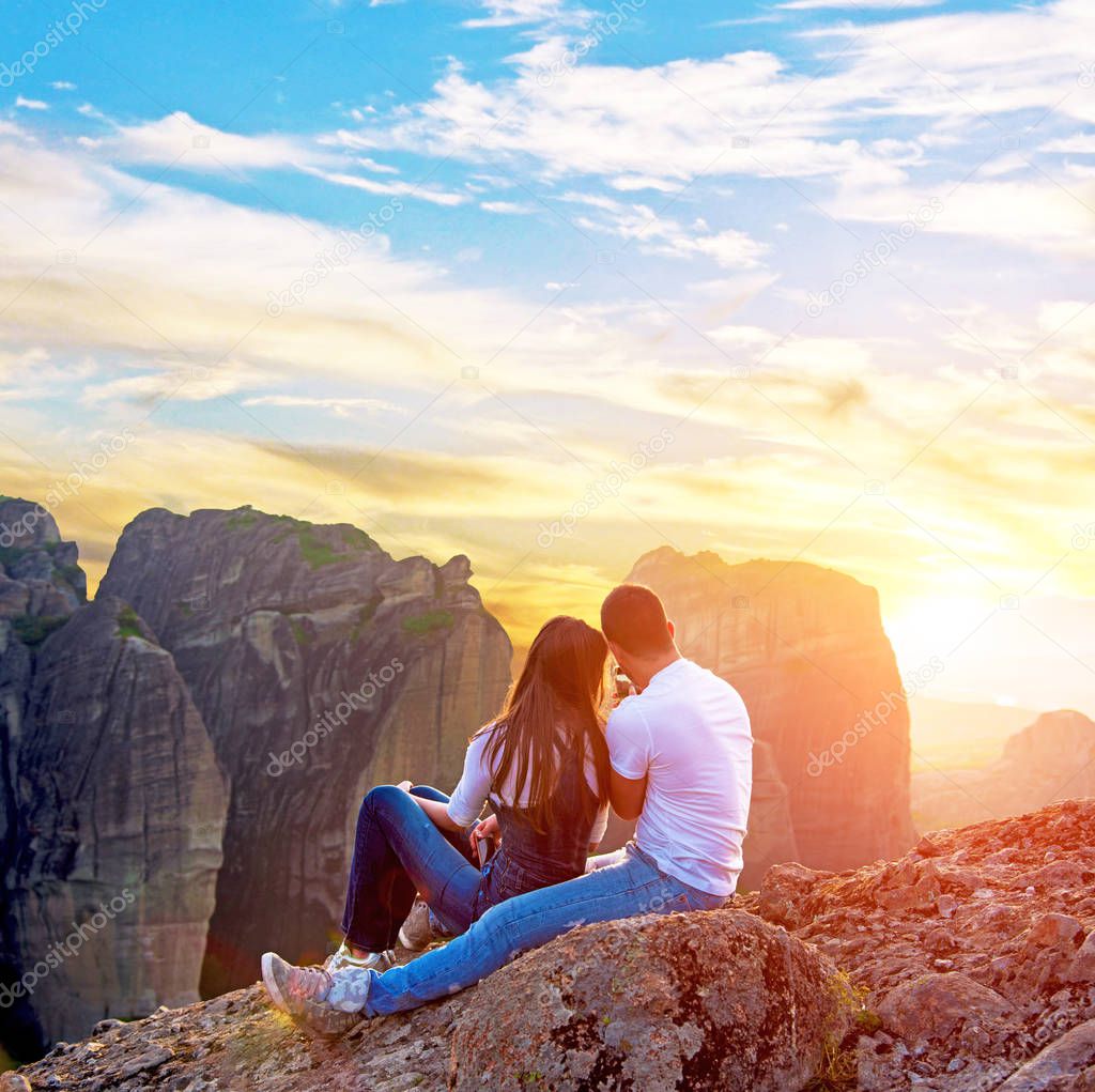 Loving couple makes a photo on a mobile phone in the mountains at sunset