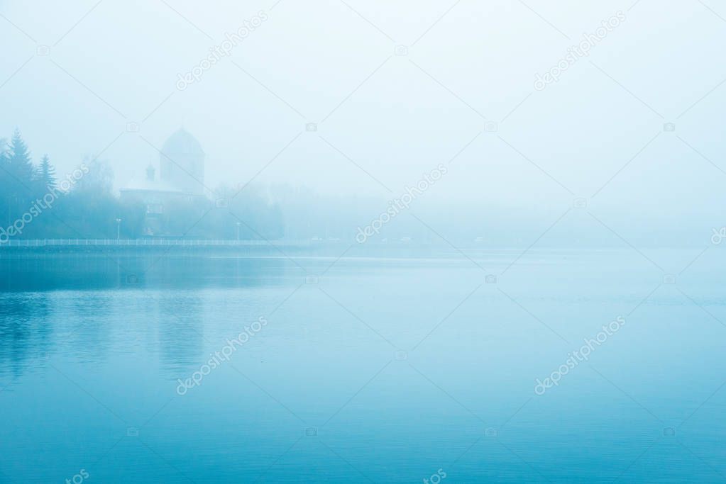 mystical landscape with the old church above the lake in the misty morning in Ternopil, Ukraine